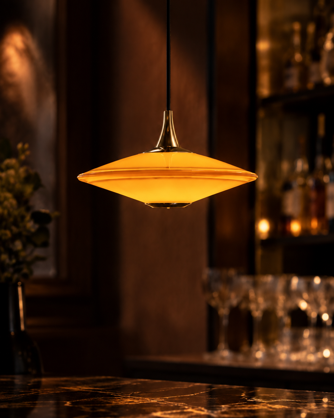 Amber glass bar pendant casting a warm glow over a dark stone counter