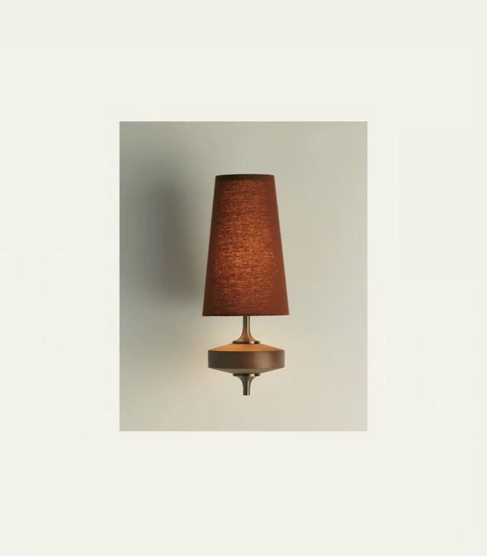 Rust fabric wall lamp glowing against a neutral wall