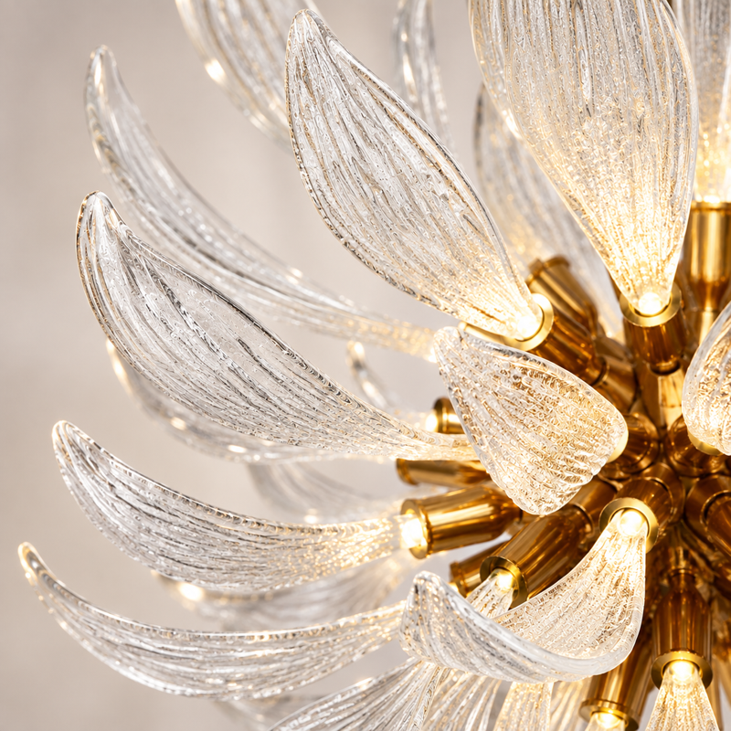 Close-up of clear ridged glass leaves and golden-toned chandelier fittings