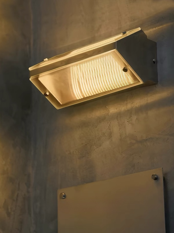 Angled view of the illuminated Lumen Vault Wall Light