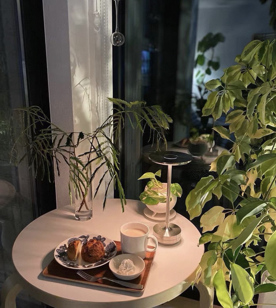 Aurelia Halo lamp in a plant-filled dining nook