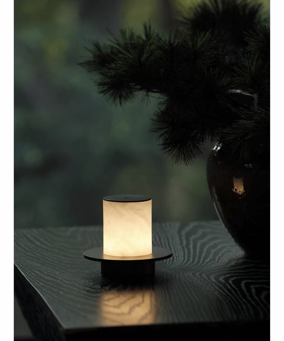 Halo Veil lamp glowing beside greenery