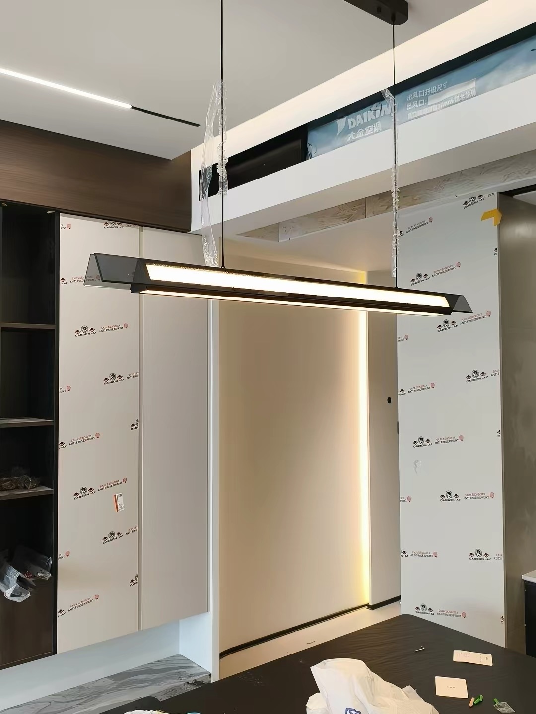 Two matching compact white pendants above a travertine kitchen island with oak cabinetry