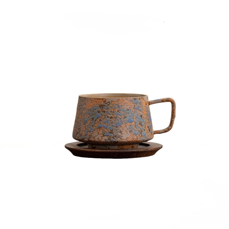 Mix Blue cup with blue-grey, copper, and brown mottling on a wooden saucer