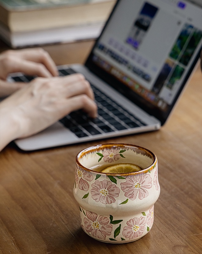 Blush Petal cup with a lemon slice in tea beside a laptop