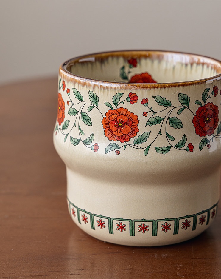 Crimson Blossom cup with red flowers, green vines, a cream body, and a brown rim