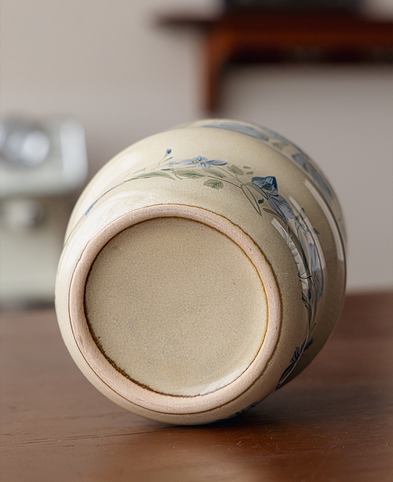 Blue Botanica cup lying on its side, showing its recessed base and unglazed foot ring