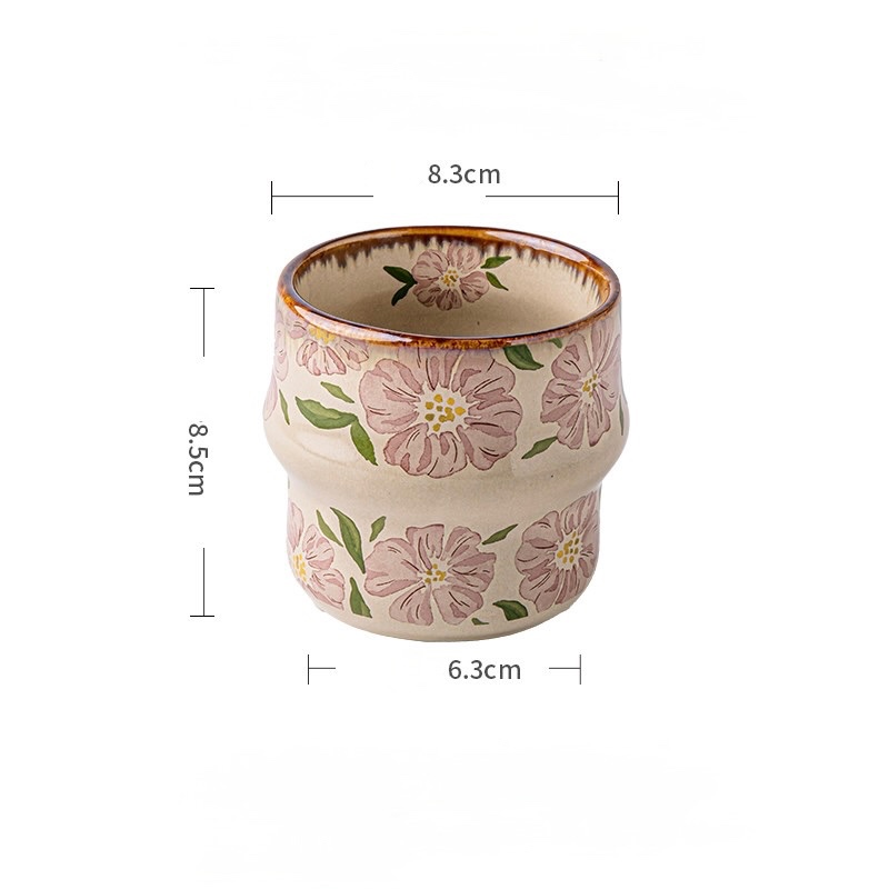 Blush Petal cup with large pink flowers, green leaves, and a brown rim