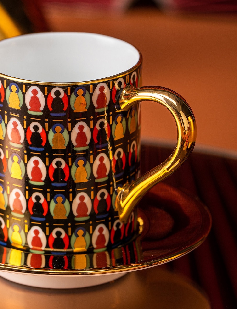 Close-up of the onyx cup’s colourful figure pattern, white interior, and reflective gold-tone handle
