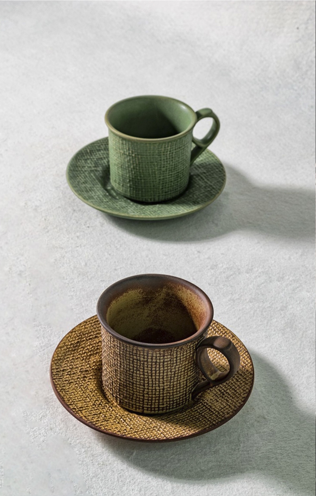 Moss Green and Toasted Amber cups arranged on matching saucers