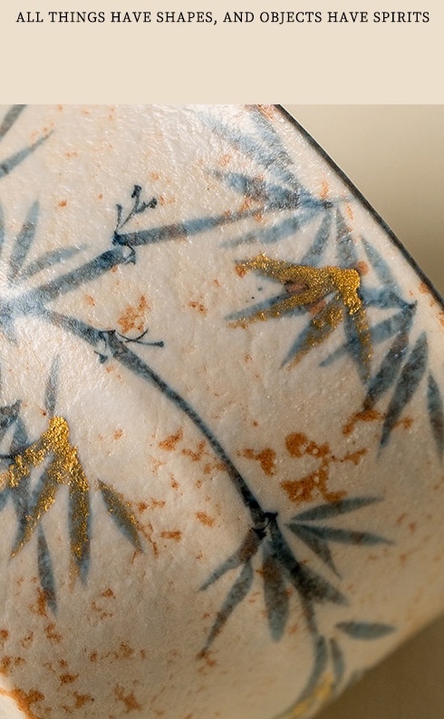 Close-up of blue-grey bamboo and gold-coloured accents on the textured cream surface