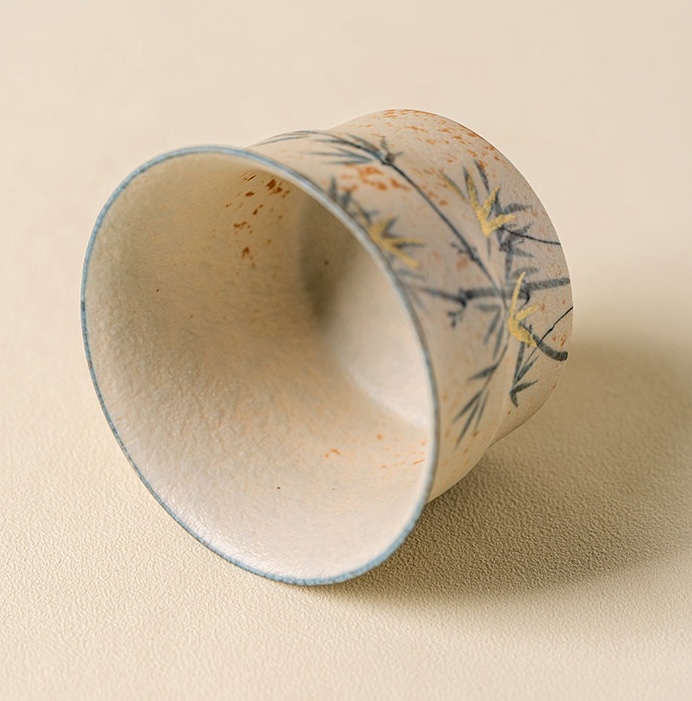 Tea cup tipped on its side showing the pale interior and fine blue-grey rim