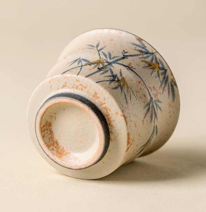 Tea cup resting on its side to show the recessed base and dark foot ring